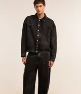 Pantalón masculino de jeans azul oscuro con efecto lavado, corte super baggy, cintura con trabillas, cierre tradicional, bolsillos y detalles de desgaste.