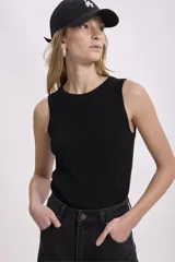 Musculosa corta de tejido de punto acanalado, color negro, con cuello redondo y sisas amplias.