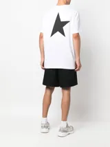 Remera blanca de algodón con cuello redondo y manga corta. Presenta un pequeño logo estampado en negro en el pecho izquierdo con el texto "STAR GOLDEN GOOSE".