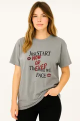 Remera gris con estampado de texto en negro y rojo.