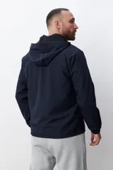 Campera deportiva negra con capucha y cierre frontal.