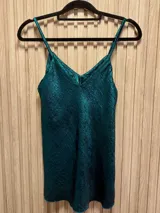 Top metalizado color verde esmeralda, de breteles finos y corte clásico.