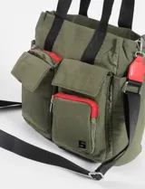 Bolso tipo shopper color verde militar, con múltiples bolsillos frontales con cierre y solapa. Tiene doble asa corta y correa larga regulable extraíble.