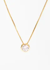 Collar dorado con cadena fina y dije circular con piedra blanca brillante.