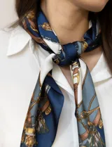 Pañuelo cuadrado de satén con estampado de cadenas doradas y detalles en rosa y blanco.
