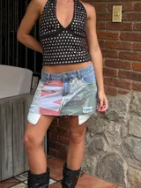 Minifalda de jean con diseño patchwork que combina denim, estampado camuflado, tela con estampado de letras y apliques de tela blanca.
