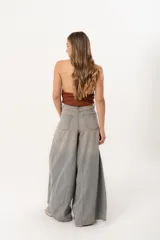 Jean súper campana de tiro alto, color celeste vintage, con pierna extra ancha y caída fluida. Cuenta con bolsillos delanteros y traseros, y cierre frontal con cremallera y botón metálico.