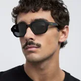 Lentes de sol con montura poligonal negra y lentes polarizadas negras. Protección UV400. Fabricados con material bio-based. Diseño equilibrado entre comodidad y durabilidad.