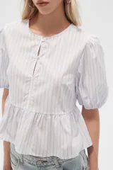 Blusa de algodón a rayas verticales color celeste y blanco, con cuello redondo, mangas cortas abullonadas y corte peplum.