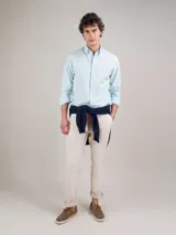 Camisa de hombre de corte regular fit, confeccionada en tejido oxford a rayas verticales celestes y blancas. Tiene cuello button-down, cierre con botones, manga larga con puño simple y logo bordado en el pecho.