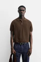 Polo gris de punto con textura, corte regular, cuello solapa y cierre frontal con botones.