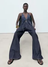 Pantalón de jean wideleg de tiro bajo con cierre de botón y cremallera, cinco bolsillos y diseño largo.