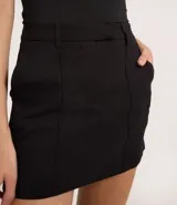 Short pollera negro de bengalina con cintura fija, trabillas, cierre tradicional y frisos.