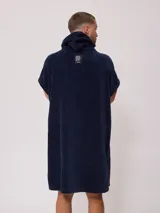 Poncho con capucha confeccionado en tejido de toalla de algodón, color negro, con el logo de la marca Rusty bordado en blanco en el frente.