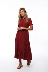 Vestido midi color borgoña, con cuello camisero, manga corta y falda escalonada.