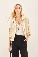 Campera marrón de lino con cierre frontal y bolsillos con solapa. Tiene mangas largas con presilla interna para arremangar.