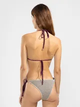 Conjunto de bikini de lurex color dorado con tiras finas color violeta.