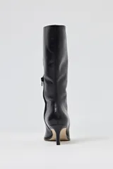 Bota de caña media de cuero negro, con punta fina y taco aguja de altura media.