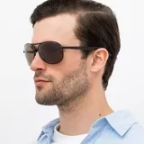 Lentes de sol INVU modelo B1606D, con montura metálica negra, lentes marrones polarizados y patillas marrones.