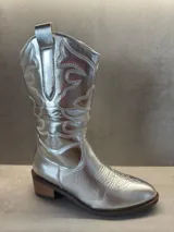Botas texanas plateadas con bordados decorativos y taco bajo.