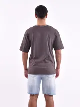 Remera gris oscuro de corte oversized con cuello redondo ribeteado en beige.