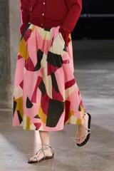Falda midi de tiro alto confeccionada en hilatura de algodón con estampado geométrico multicolor. Tiene detalle de pliegues en la cintura y bajo evasé.