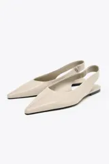 Zapato tipo bailarina destalonada color beige, con puntera fina y tira trasera elástica.