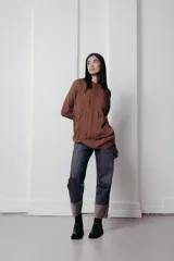 Sweater marrón de punto con diseño trenzado, cuello redondo y corte holgado.