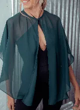 Capa corta color verde esmeralda de gasa transparente, con cuello redondo y abertura frontal con cierre de botón.