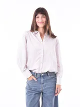 Camisa celeste con rayas verticales blancas, de corte recto y mangas largas.