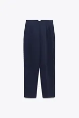Pantalón azul marino de corte cropped, tiro alto, con bolsillos laterales y cierre frontal con cremallera, botón interior y gancho metálico.