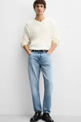 Pantalón de jean celeste de corte slim fit y tapered, con cinco bolsillos, efecto lavado y cierre frontal con cremallera y botón.