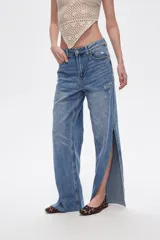 Pantalón de jean azul de tiro alto, corte recto y aberturas laterales en el ruedo.