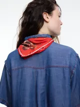 Camisa negra de manga corta confeccionada en denim liviano de tencel, de calce cuadrado y relajado. Presenta cierre frontal con tapeta escondida y costuras en color contraste.