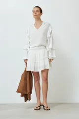 Minifalda blanca de bambula con volados y cintura elastizada.