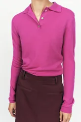 Jersey de lana color fucsia con cuello polo y tapeta con botones.