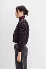Campera bomber con estampado animal print, cuello redondo y corte a la cintura. Presenta detalle de cartera bordada en piedras y strass.