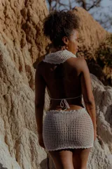 Top tejido al crochet color negro, con capucha integrada y diseño artesanal.