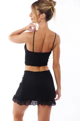 Minifalda negra de encaje con volados en el ruedo.