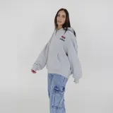 Canguro gris con capucha y cordones ajustables, puños y cintura acanalados, bolsillo tipo canguro y logo estampado en el pecho.