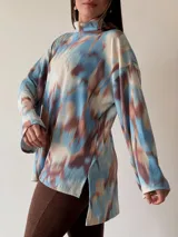 Sweater de cuello alto con estampado abstracto en tonos celeste, marrón y blanco.