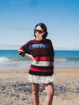 Buzo tejido con diseño de rayas horizontales en tonos marrón, azul, verde y blanco.