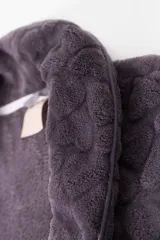 Bata larga de poliéster color gris oscuro con textura acolchada en forma de rombos, cuello tipo chal, bolsillos laterales y cinturón.
