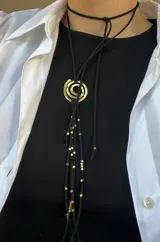 Collar de gamuza marrón con dije de espiral dorado y cuentas de bronce.