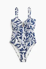 Traje de baño enterizo con estampado floral en azul y blanco, con breteles ajustables extraíbles, alambre en forma de U en la parte central del busto, copas con relleno extraíble, piernas de corte alto y cobertura media en la parte de atrás.