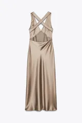 Vestido largo de satén color champagne, con escote en pico, tirantes anchos cruzados en la espalda y ribetes negros en contraste.