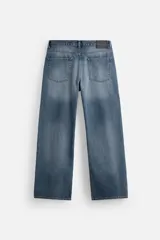 Pantalón de jean celeste con efecto lavado, corte flare fit y caída baggy desde la rodilla hasta el tobillo. Tiene cinco bolsillos y cierre frontal con botones.