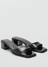 Sandalia de mujer en color negro con diseño minimalista y tacón bajo.