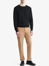 Sweater negro de algodón con cuello redondo, mangas largas con puños acanalados y logo de la marca bordado en el pecho.
