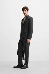 Pantalón de vestir slim fit color gris oscuro, confeccionado en tejido con viscosa. Cuenta con bolsillos frontales y traseros de vivo. Cierre frontal con cremallera y botón.